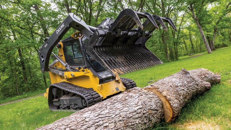 333 P-Tier compact track loader with grapple attachment ready to pick up and move large logs.