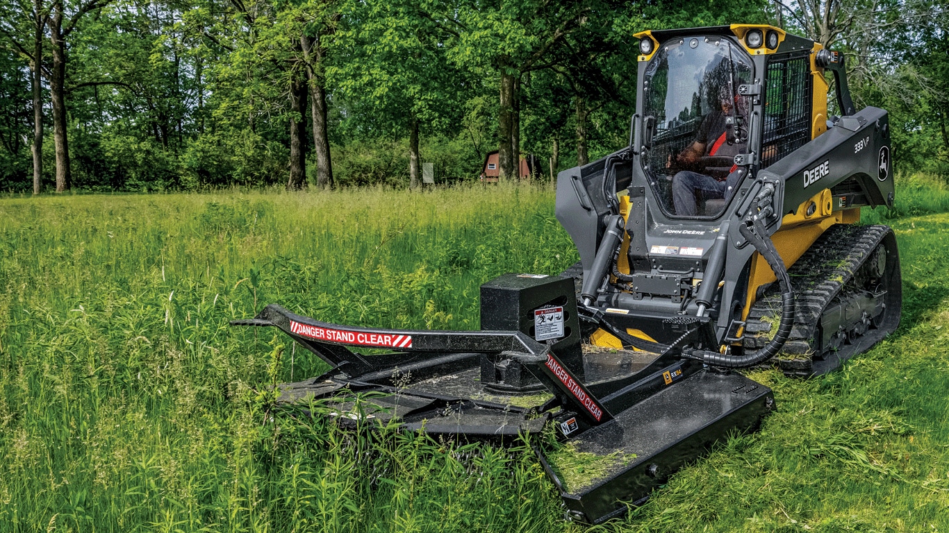 333 P-Tier compact track loader using rotary cutter to trim grass and brush.