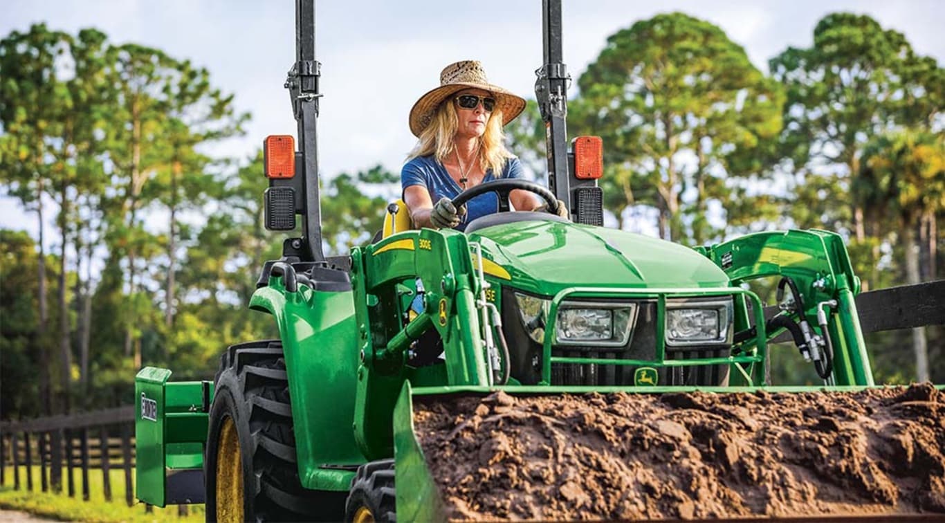 A person moving dirt with her 3025E Tractor.