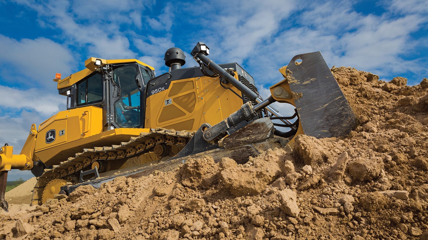 A close-up of a 950K Dozer pushing dirt on top of a stockpile.