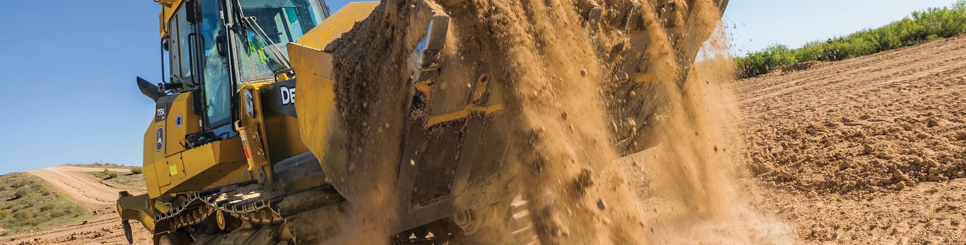 Deere crawler loader loading dirt on worksite