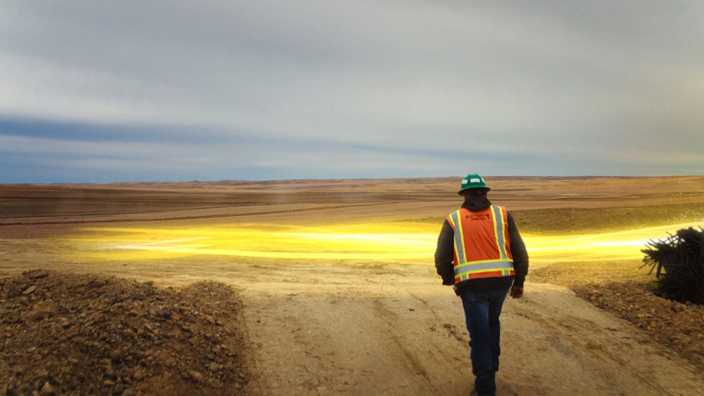 Yellow light path moving past a construction worker on a building site.