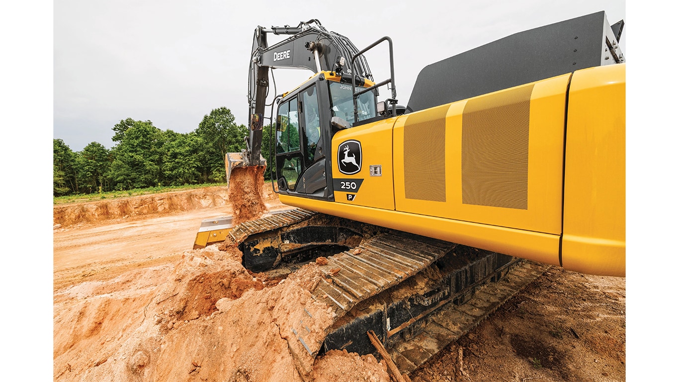 A close-up of the 250P-Tier Excavator as it dumps dirt into a worksite pit.