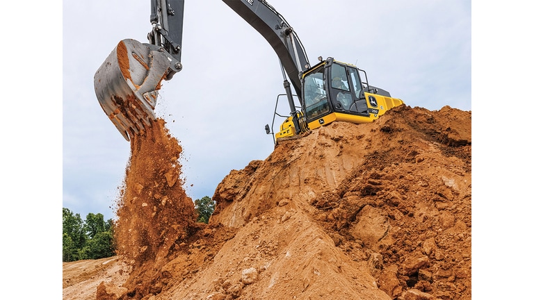 Una Excavadora 250P-Tier descarga tierra en un pozo desde la parte superior de una pila.