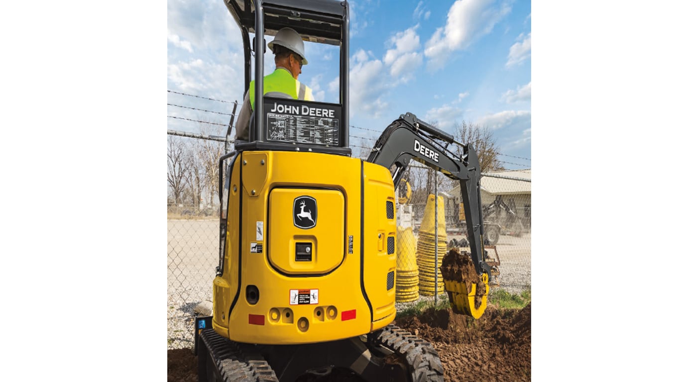 The backside of a 30P-Tier Excavator scooping dirt from a pile to the right of the machine.