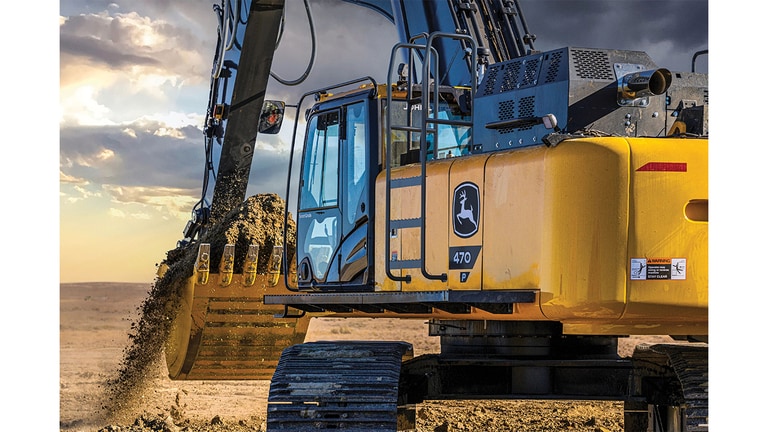A rear-view perspective of a 470P-Tier Excavator moving dirt at a worksite.
