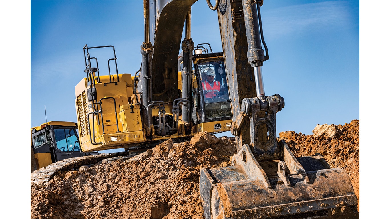 An operator using a 670P-Tier Excavator to scoop up dirt at a worksite.