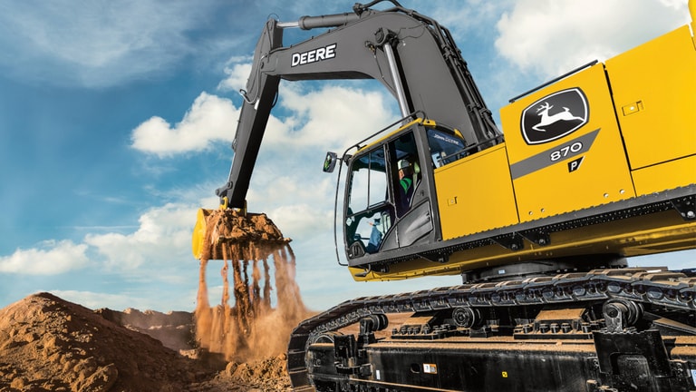 An operator using the 870P-Tier Excavator to move dirt at a worksite.