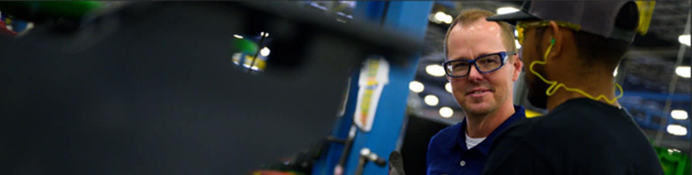 Two people talk in a factory environment