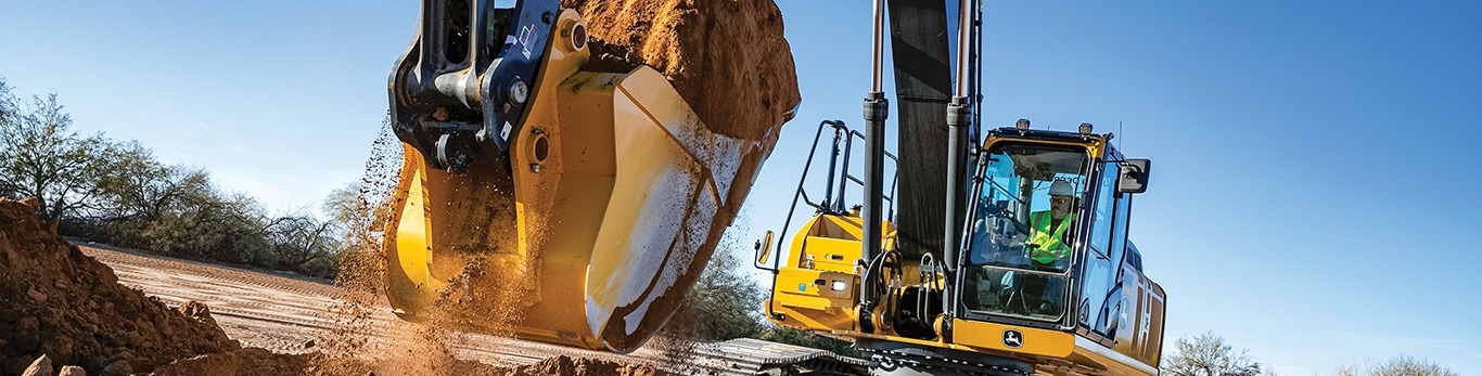 John Deere Excavator moving dirt on a worksite.