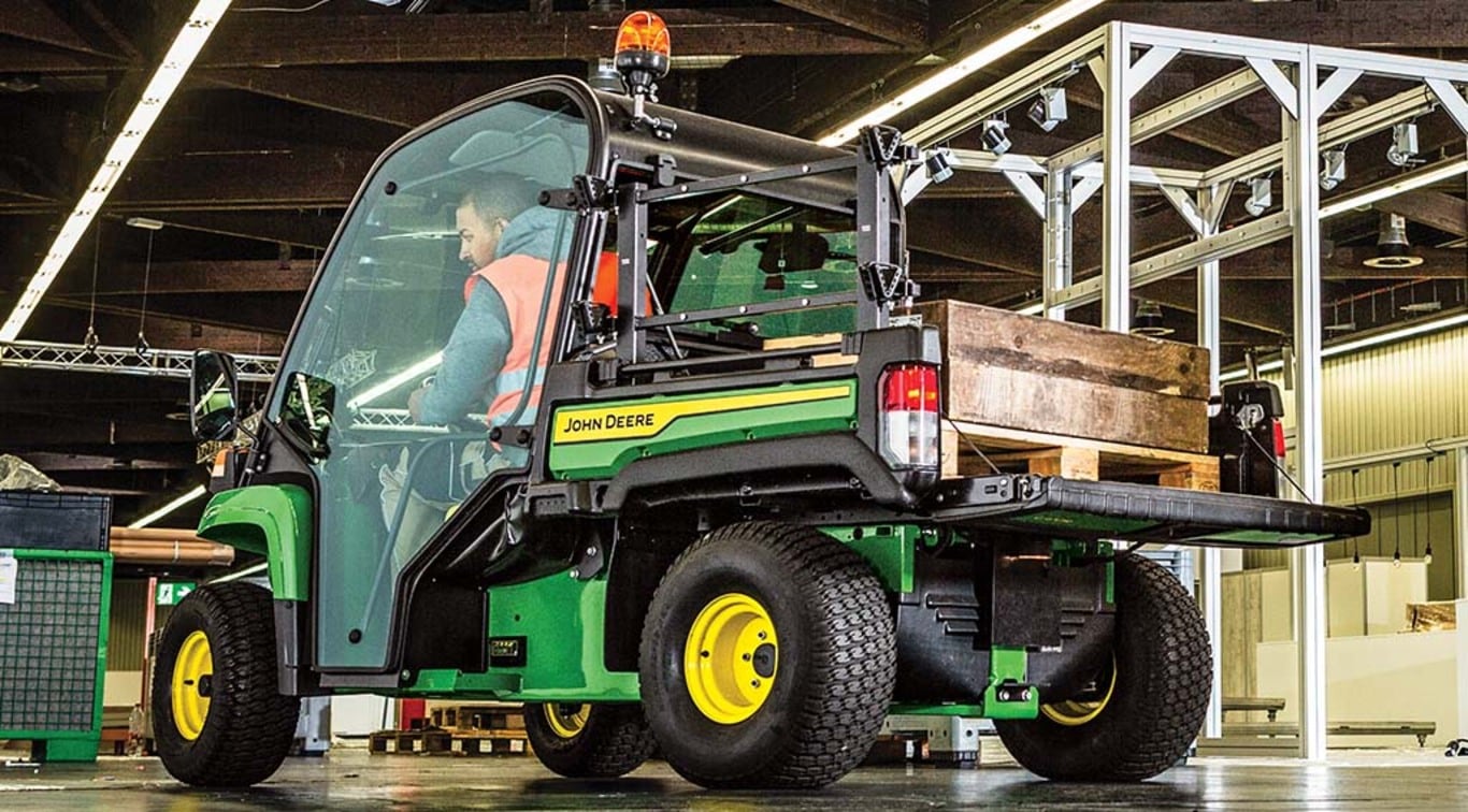 man driving a TE Gator carrying supplies around a warehouse