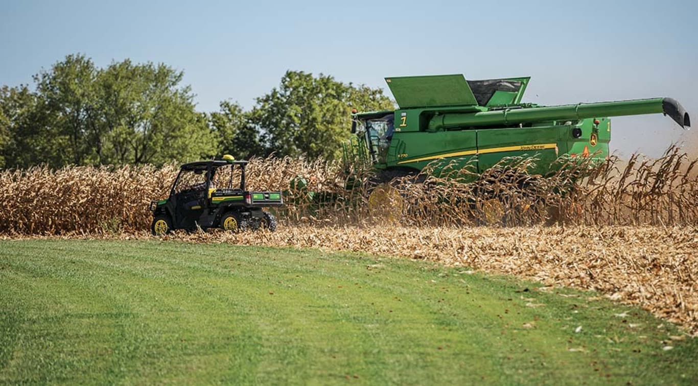 a XUV835M Gator driving in a harvest field.