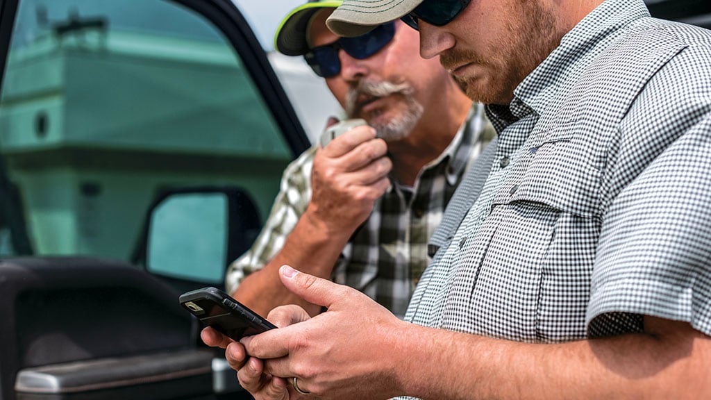 Two men looking at a cell phone screen