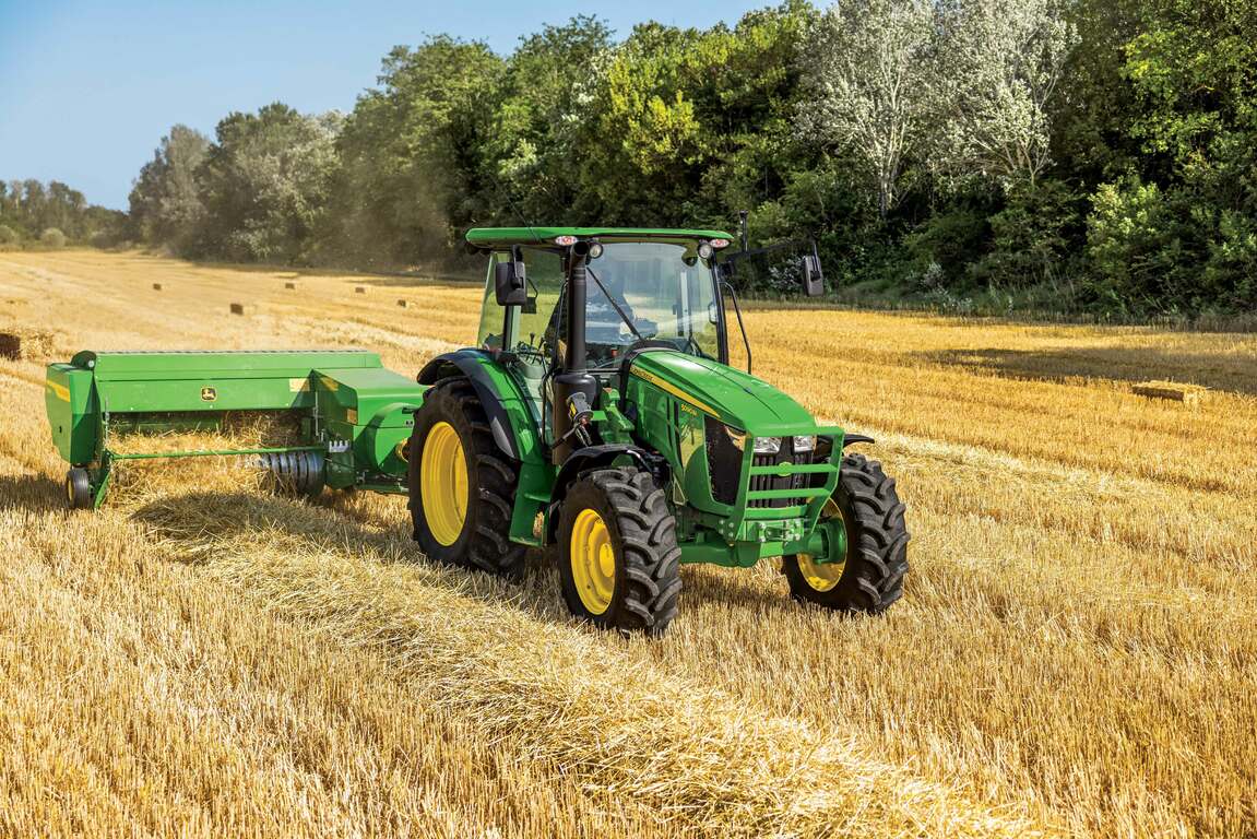 5 Series Tractor pulling an S200 small square baler in a field of hay.