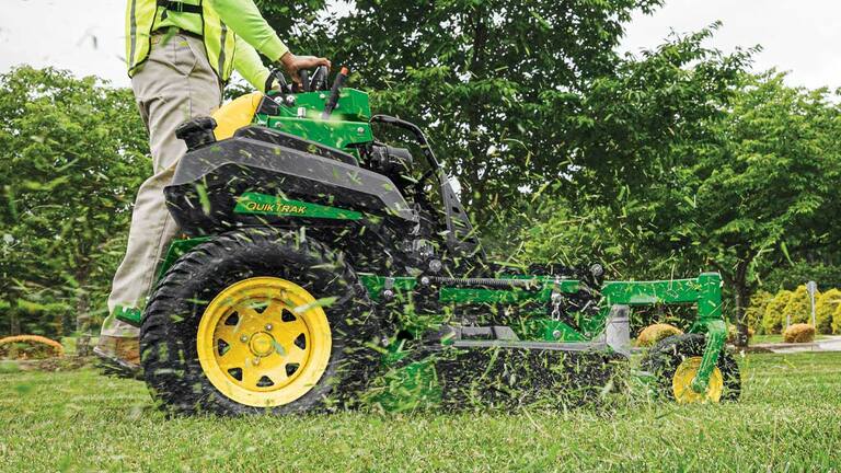 Side view of grass clippings being discharged from a Q850R QuikTrak Stand-on mower mower deck.