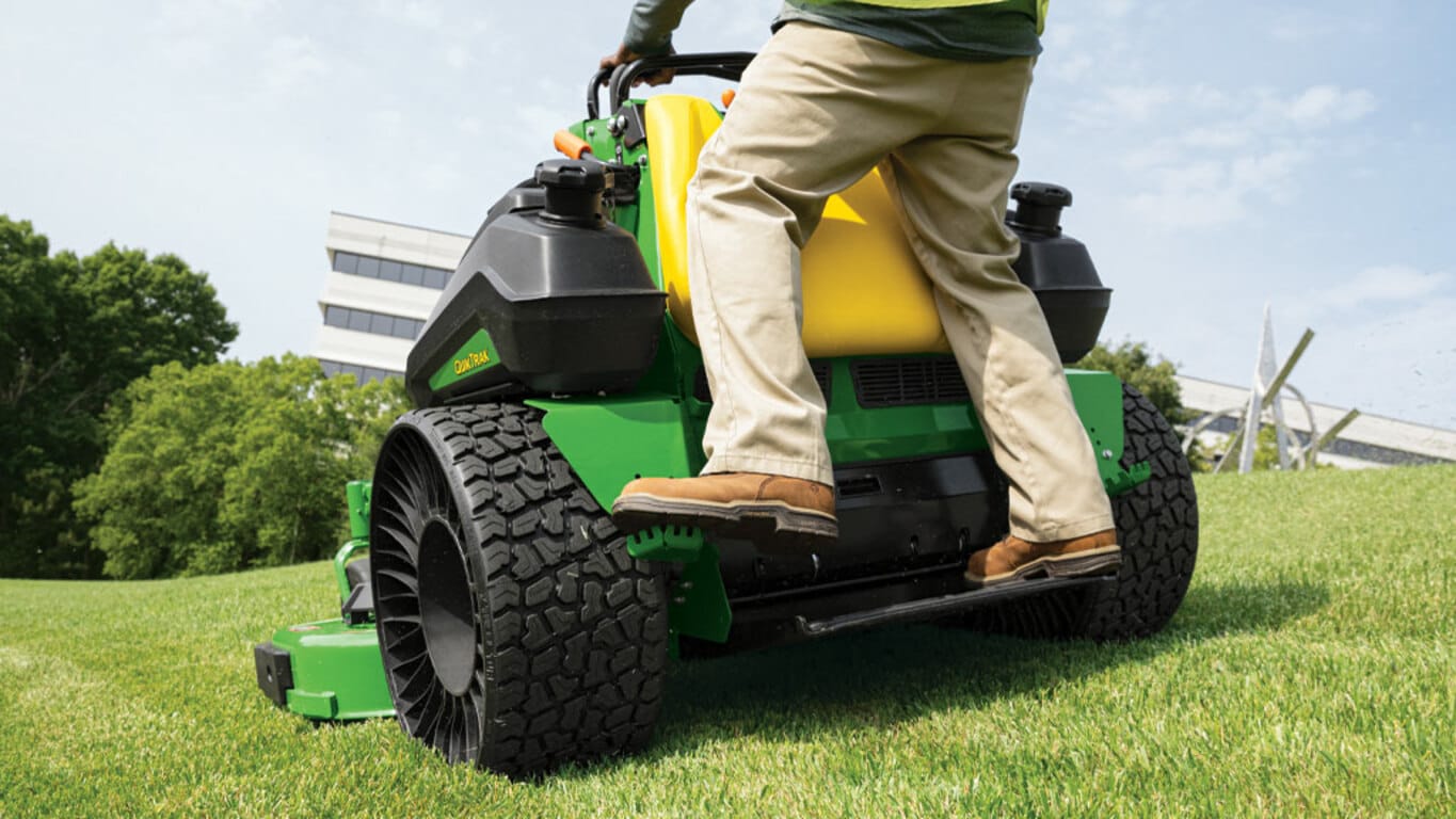 Rear close up of a person mowing grass on a Q850R QuikTrak Stand-on mower with Tweels