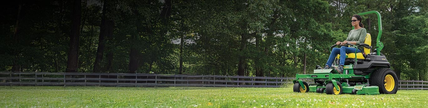 A woman mowing her lawn with a John Deere Z760R ZTrak™ Zero-Turn Mower.