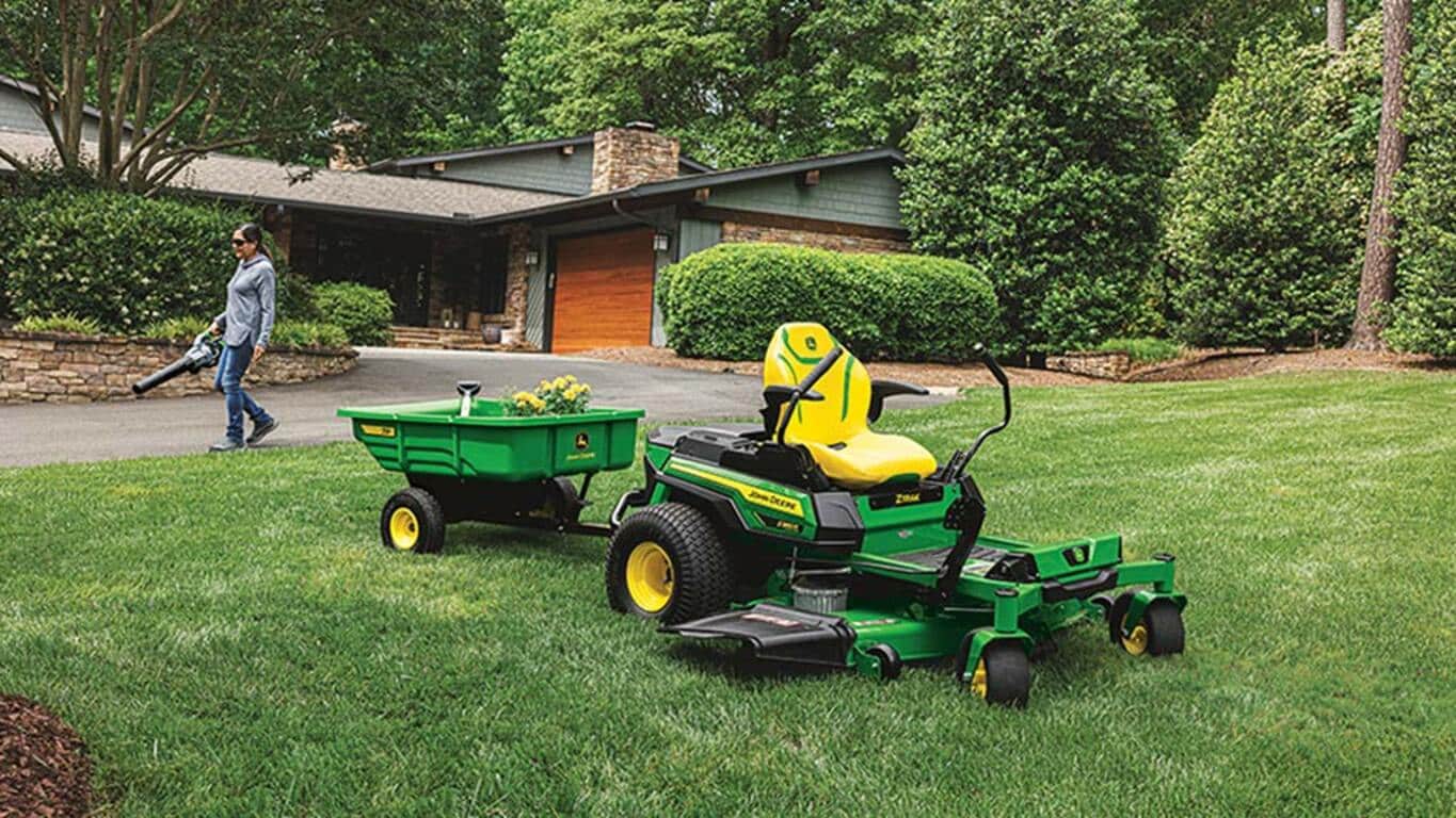 Person blowing grass with a Z380R, with 7P car attached, in the foreground