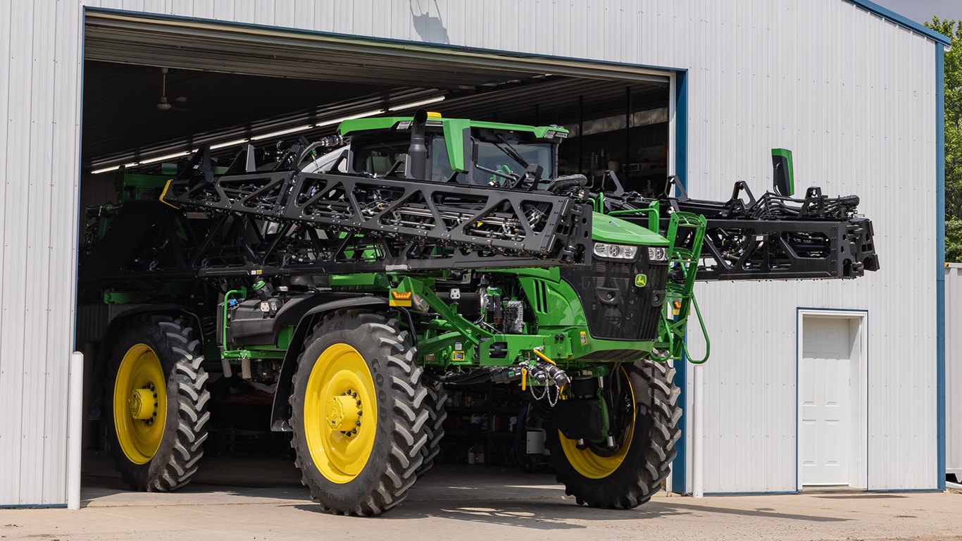 Sprayer pulling out of a shed.