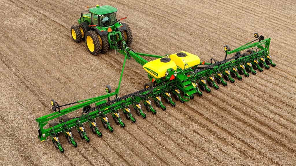 Overhead photo of a John Deere tractor pulling a planter in a field.
