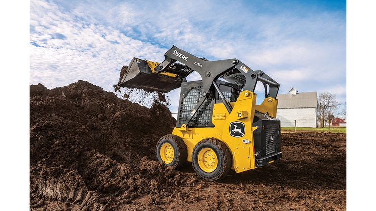 A 318G Skid Steer moves dirt at a worksite with a house in the background.