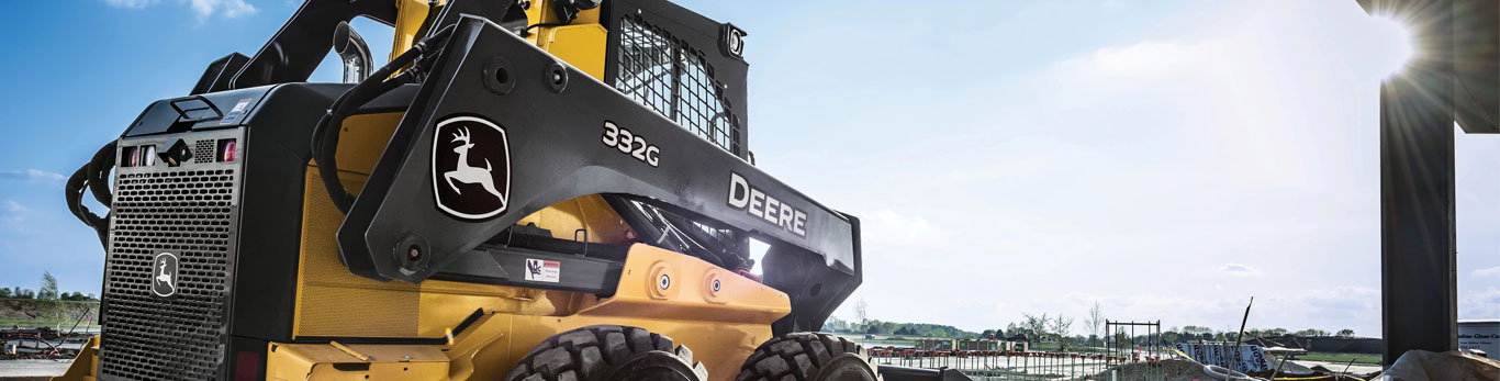 332G Skid Steer with bucket attachment faces worksite.