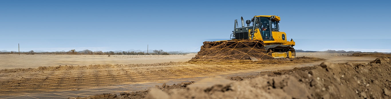 A John Deere dozer pushes dirt, with the ground layered with a grid to indicate automation.