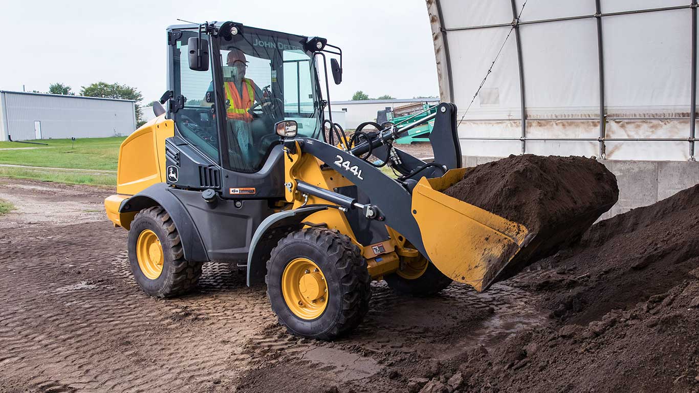 244L mini loader hauling dirt