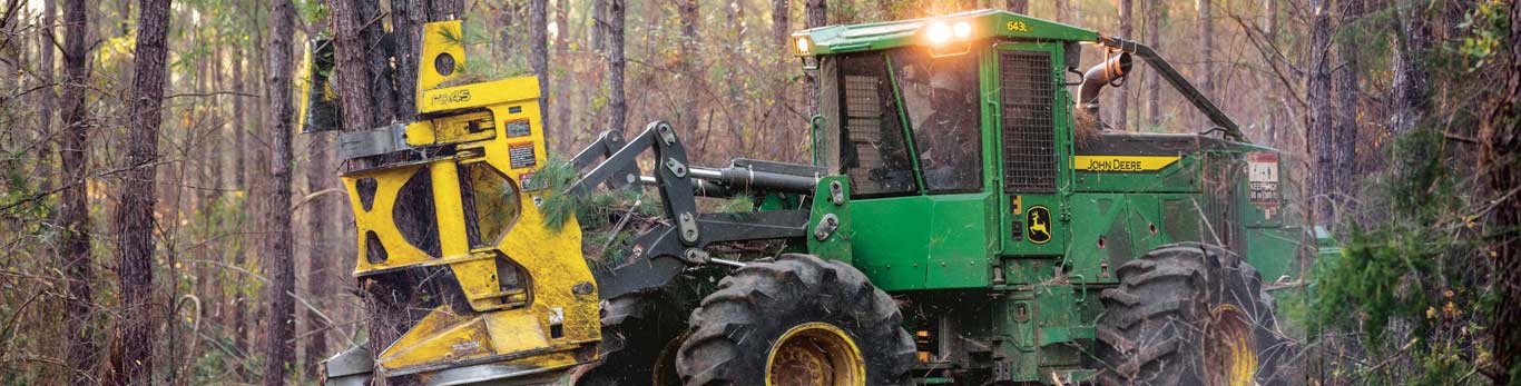 643L-II Drive-to-Tree Feller Buncher navigates through the forest, carrying a group of cut trees