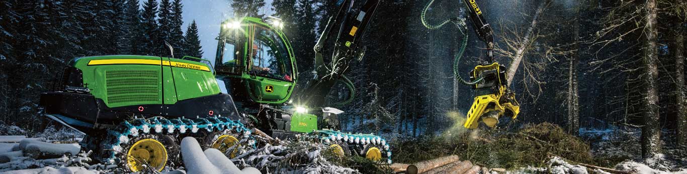 John Deere 1170G Wheel Harvester works in a snowy wooded area