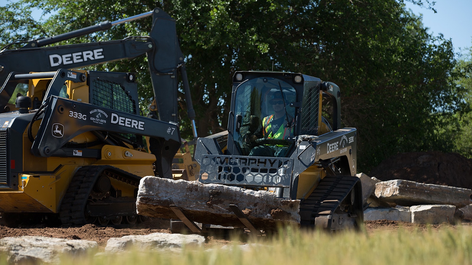 Compact track loaders haul large landscaping rocks