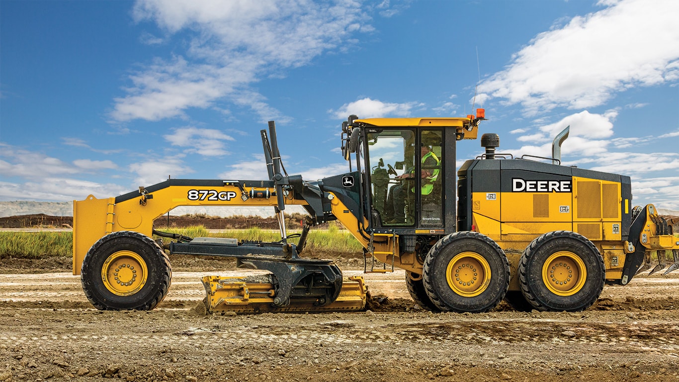 An 872GP SmartGrade™ Motor Grader leveling surface at a roadbuilding site