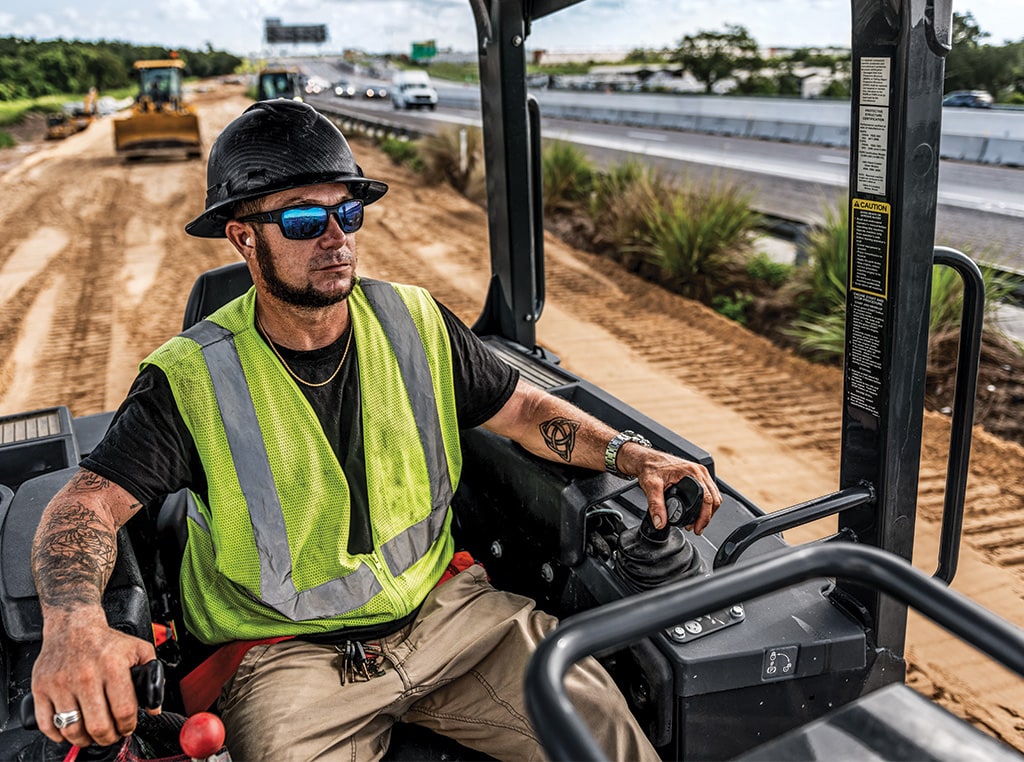 Tyler sits within the cab of a 450K LGP Dozer and uses the machine to shape the land on a corridor widening project.
