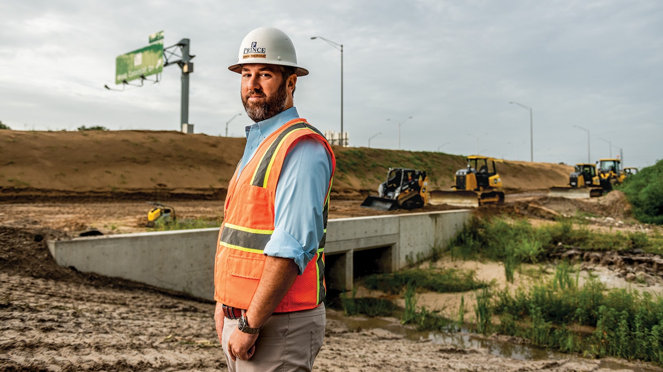 Mike poses on a Florida roadbuilding site as compact track loaders and dozers work in the background.
