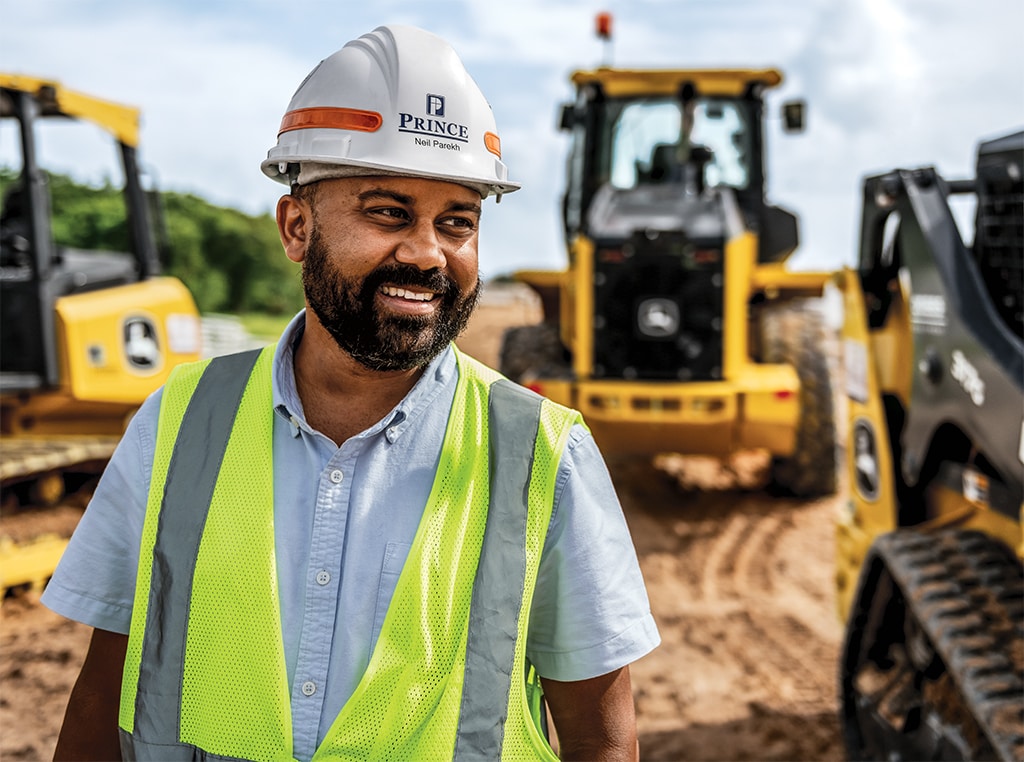 Neil is smiling as he is walking at a road widening project in Florida. 