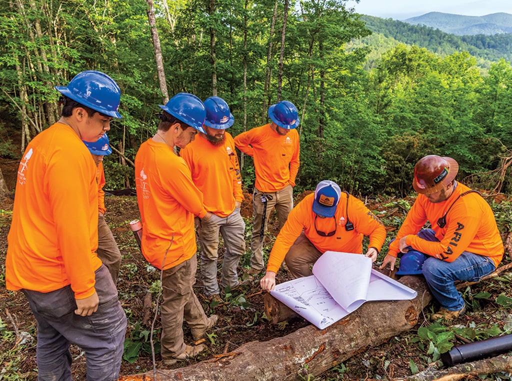 M.H.I. employees Joel Reyes, Cody Brown, Tyler Creech, Justin Hayden, Tanner Ruff, Miles Holden, and Micaiah Holden analyze elevation site plans.