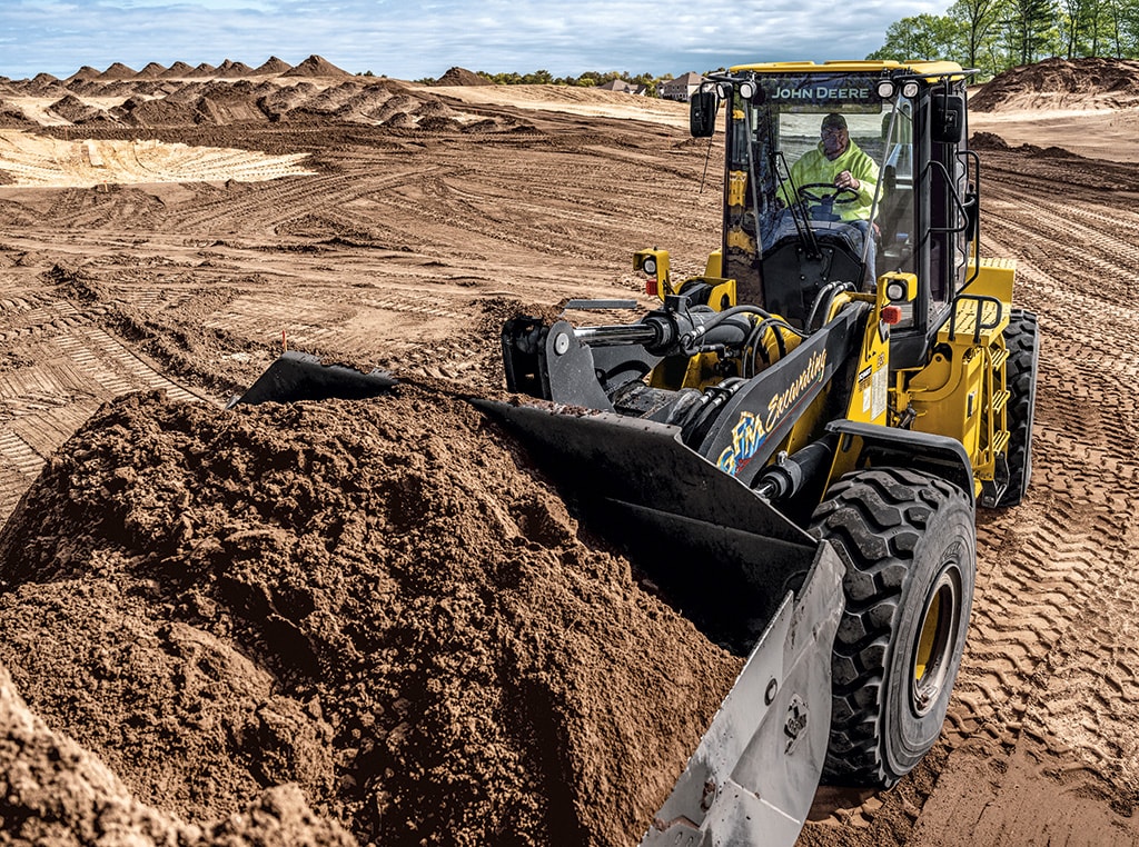 A 644 P-Tier Wheel Loader picks up dirt and moves it to another part of a jobsite in Cape Cod.