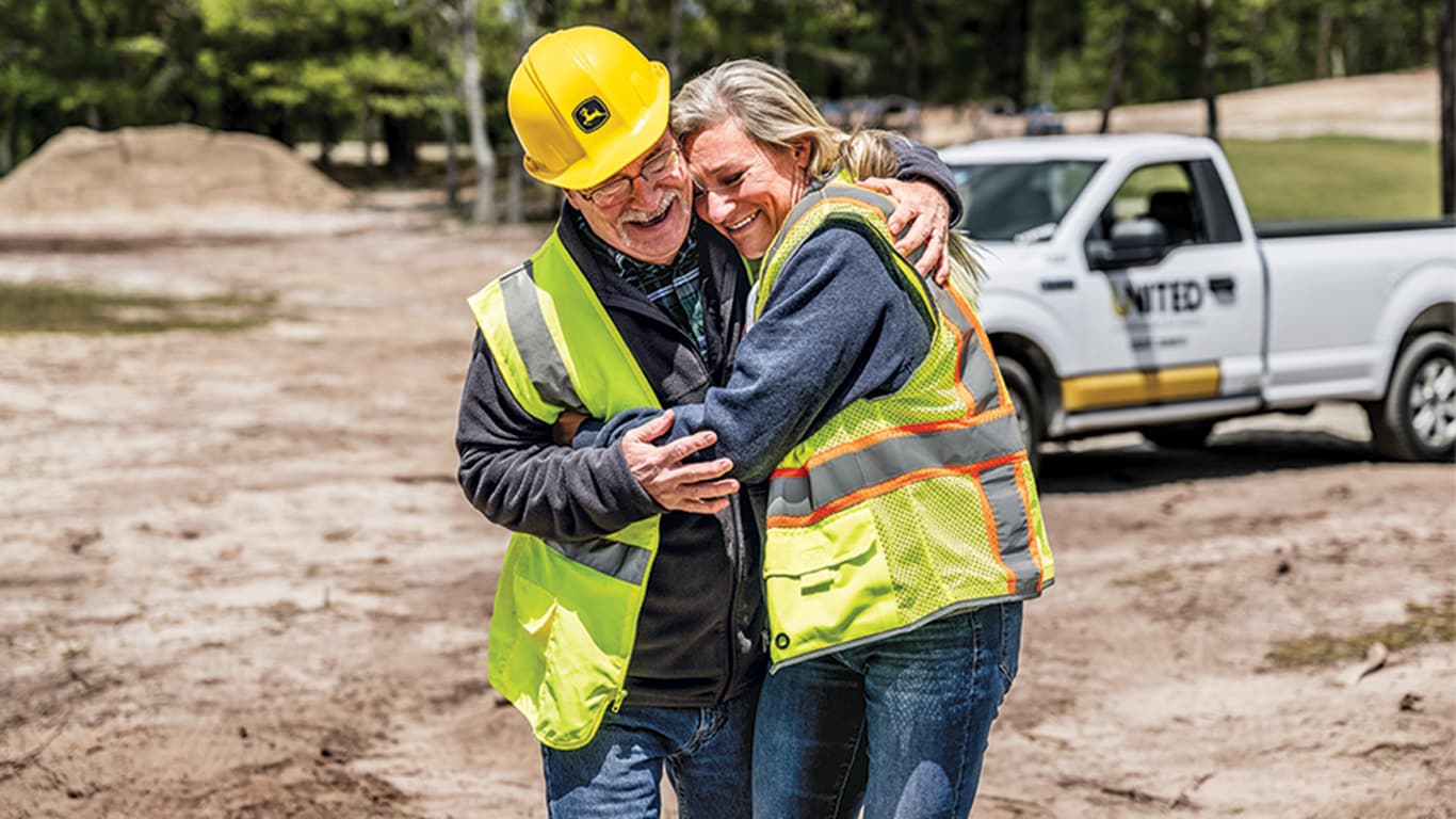 Jennifer Morris and Joe Huber share a laugh and a hug on a jobsite in Cape Cod.