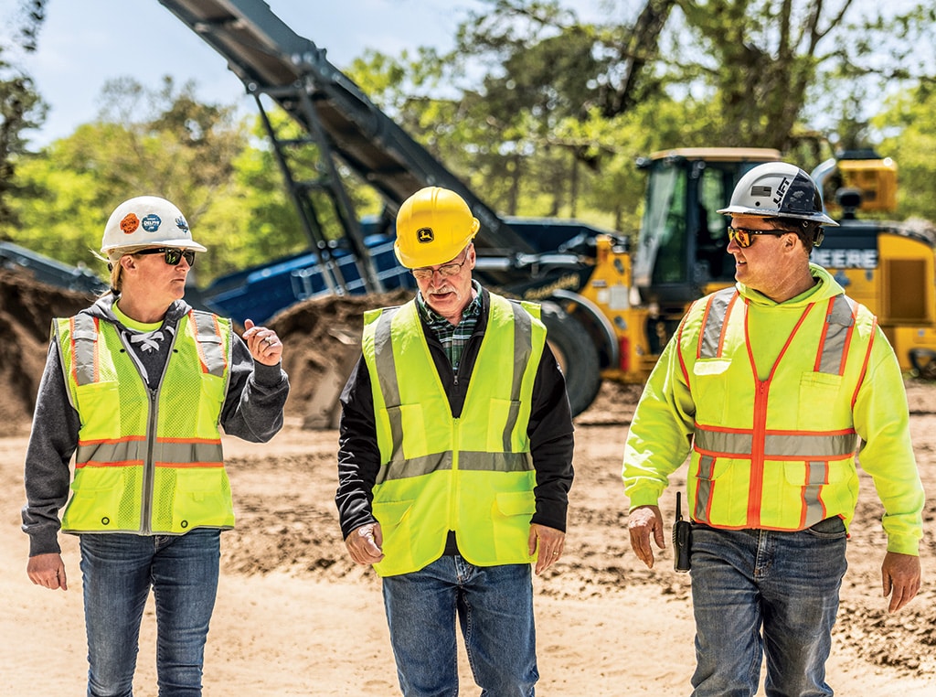 Jennifer shares a story with Joe and Greg as they walk side by side through a jobsite in Cape Cod.