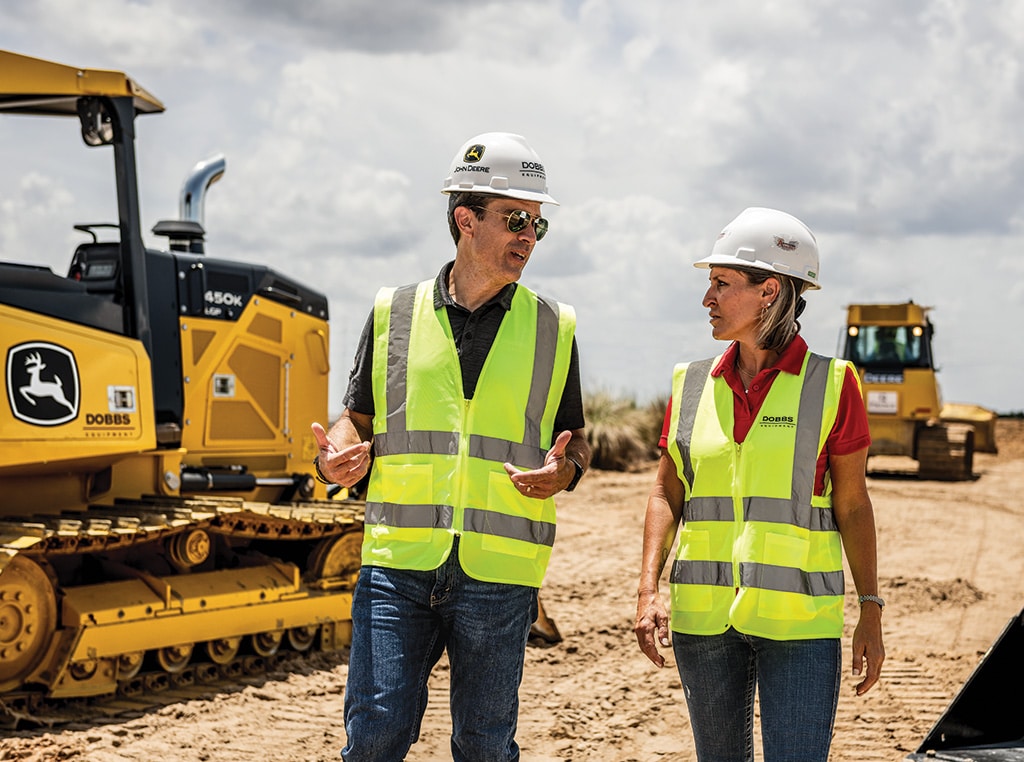 Augusto Salles speaks to Kristi Gibbs as a 450K LGP Crawler Dozer works in the background.