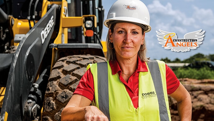 Kristi Gibbs, the founder of nonprofit Construction Angels, rests her arm on the bucket of a 524 P-Tier Wheel Loader on a roadbuilding jobsite in Florida.