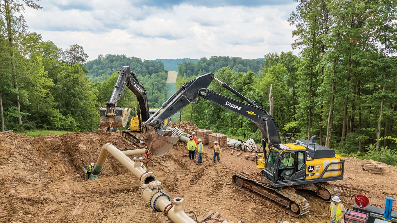A John Deere 350 G-Tier and 250 P-Tier Excavators team up to move pipes into place.
