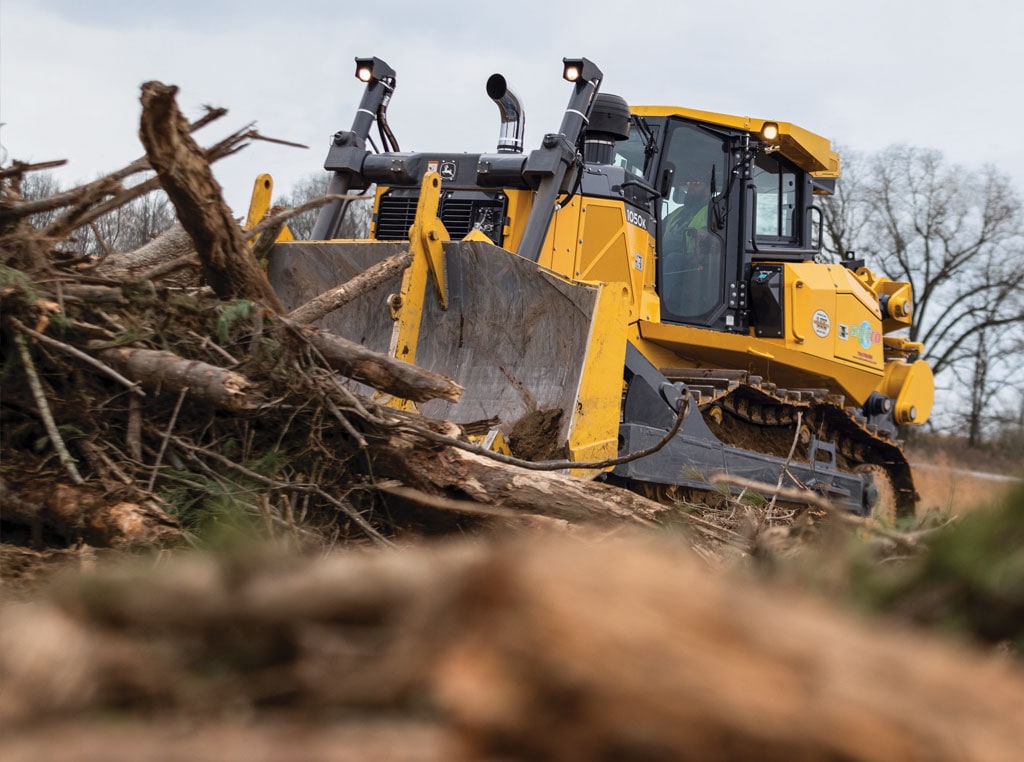 A John&nbsp;Deere 1050K clearing debris from a job site