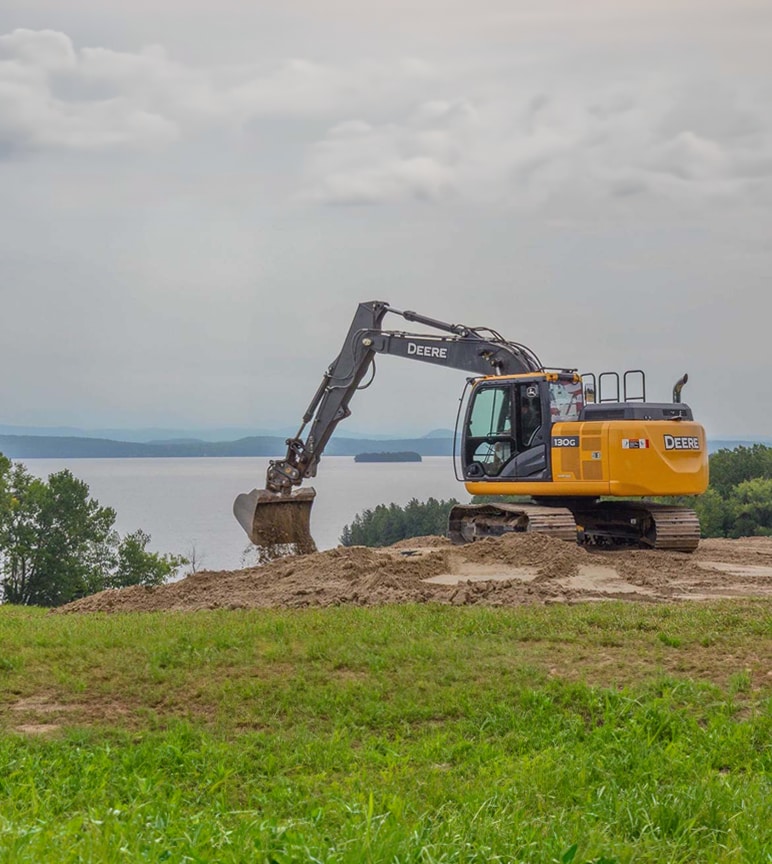 John Deere 130G Excavator with a lake in the background. 