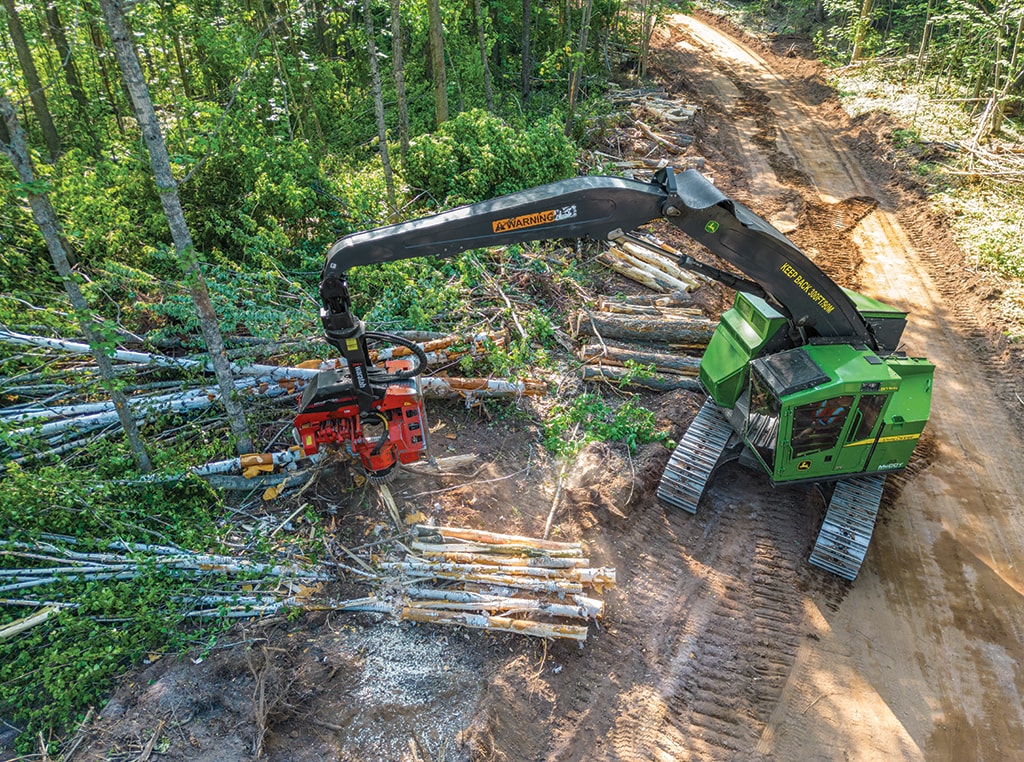 An overhead view of an 803MH Tracked Harvester processes roadside cut-to-length logs.