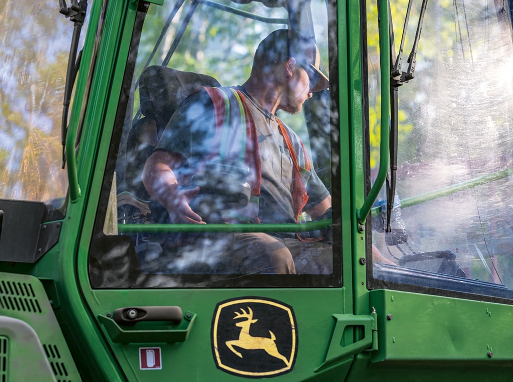 Eli Larson operates a John Deere 1210G Forwarder near the landing site in Michigan.