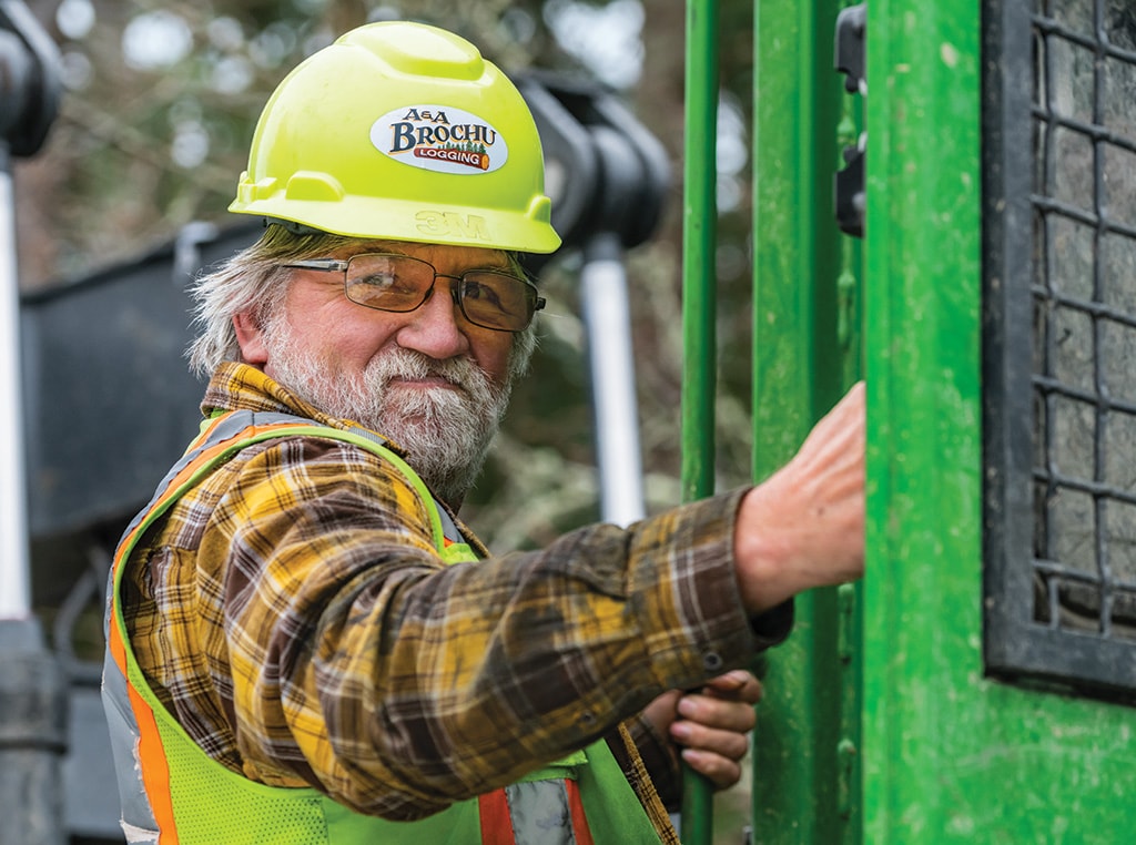 Elwood Stinson looks over his shoulder while entering the cab of the skidder.