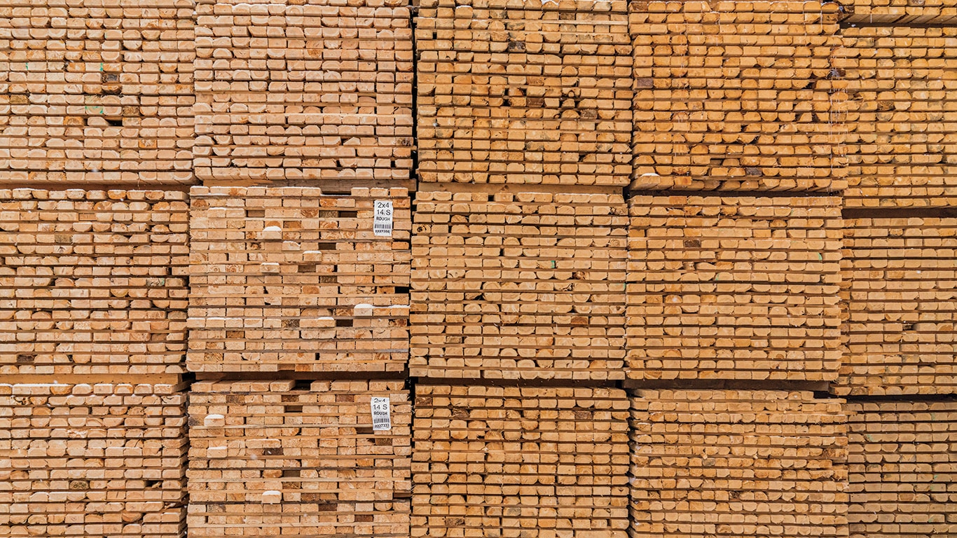 Rough-cut green lumber sits outside in massive stacks before entering the drying kiln at the Pleasant River Lumber sawmill.