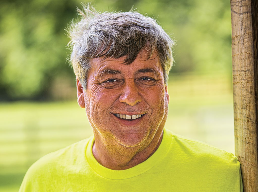 Brian Lewis smiling at camera, leaning against a doorway