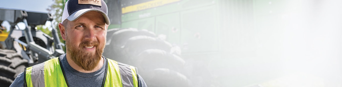 Casey poses in front of a 748L-II Grapple Skidder. 